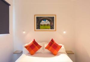 a bedroom with a bed with two orange pillows at Quaint Beach Villa in a fishing village in Grand Gaube