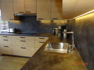 una cocina con fregadero de acero inoxidable y armarios de madera en Hüttenzauber 3 Modern retreat en Annaberg im Lammertal