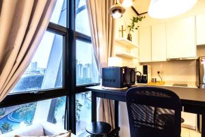 uma cozinha com um balcão com um micro-ondas e uma janela em Arte Mont Kiara by Airhost em Kuala Lumpur