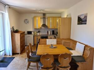 een keuken met een houten tafel en stoelen in een kamer bij Daffodil Modern Retreat in Bad Mitterndorf