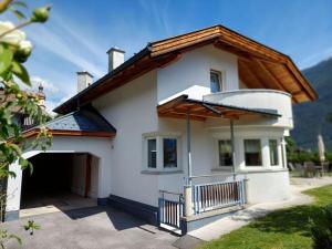 a white house with a gambrel roof and a garage at Michl"s Villa Modern retreat in Tarrenz