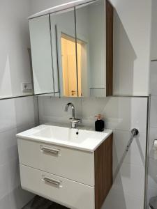 ein Bad mit einem Waschbecken und einem Spiegel in der Unterkunft Murtal Appartment in Zeltweg