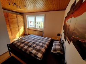 een slaapkamer met een bed en een raam bij NEU! Ferienwohnung Sommeralmblick in Schiffweiler