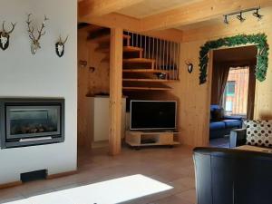 a living room with a fireplace and a television at Alpenglöckchen Modern retreat in Stadl an der Mur