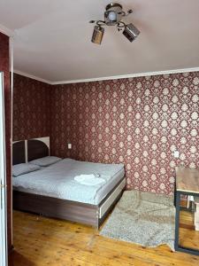 a bedroom with a bed and a ceiling fan at HOLIDAY HOTEL in Bishkek