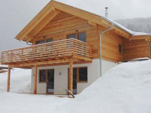 een huis met een houten dak in de sneeuw bij Hüttenzauber 1 Modern retreat in Annaberg im Lammertal
