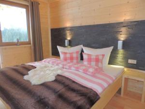 een slaapkamer met een groot bed met roze en witte kussens bij Hüttenzauber 1 Modern retreat in Annaberg im Lammertal