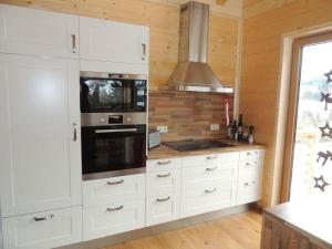 a kitchen with white cabinets and a stove top oven at Hüttenzauber 1 Modern retreat in Annaberg im Lammertal