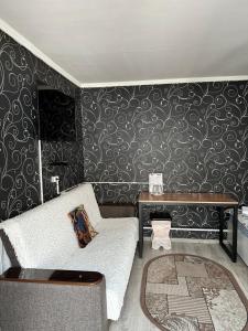 uma sala de estar com um sofá e uma mesa em HOLIDAY HOTEL em Bishkek