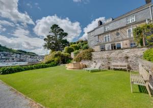 a garden with two benches in front of a building at Ravenswell in Dartmouth