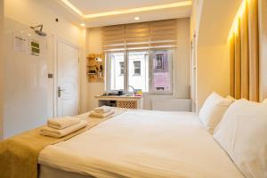 イスタンブールにあるエミール ホテルのベッドルーム1室(大きな白いベッド1台、タオル付)