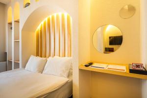 イスタンブールにあるエミール ホテルのベッドと鏡が備わるホテルルーム