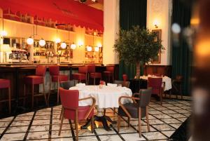 杜拜的住宿－Ritz Carlton DIFC Downtown Dubai，一间带桌椅的用餐室和一间酒吧