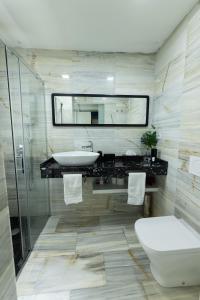 een badkamer met een wastafel, een toilet en een spiegel bij Singular Home Sevilla Center Bikes free in Sevilla