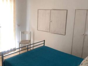 una camera da letto con un letto con una coperta blu e armadi di Holiday apartment in Porto Pollo a Porto Pollo