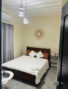 Schlafzimmer mit einem Bett und einem Wandspiegel in der Unterkunft City Villa in Tagbilaran