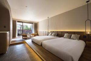 a bedroom with a large white bed and a table at nol hakone myojindai in Hakone