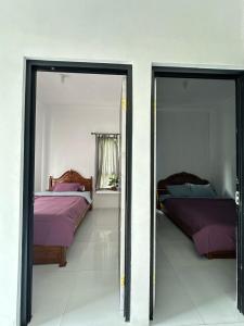 two beds in a room with two mirrors at Abimanyu Guesthouse in Sumedang