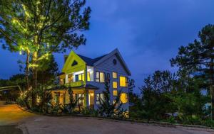 a house with a blue and yellow house at Love Hill Resort in Da Lat