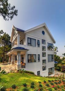 a large white house with a yard at Love Hill Resort in Da Lat