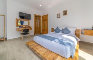 een slaapkamer met een groot bed en een bureau bij Love Hill Resort in Da Lat