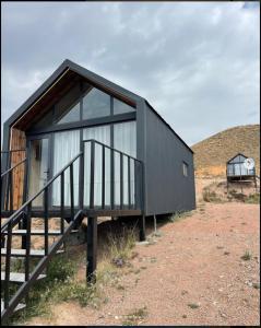 a small black building with a staircase in a field at Eagle House in Bosteri