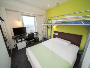 - une chambre avec des lits superposés et un bureau dans l'établissement Super Hotel Tozai line Ichikawa Myoden Ekimae, à Ichikawa