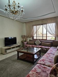 ein Wohnzimmer mit Sofas und einem Kronleuchter in der Unterkunft la perle du tanger R in Tangier