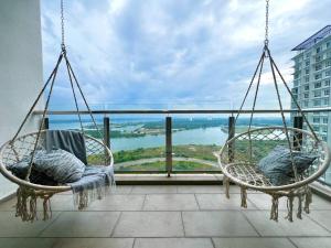 two swings on a balcony with a view of the water at Bora Residences by Antlerzone in Johor Bahru