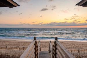 a wooden stairway to the beach at sunset at Dune it Wright at Carolina Shores in Nags Head