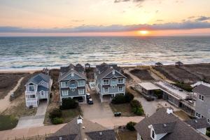 an aerial view of houses on the beach at sunset at Dune it Wright at Carolina Shores in Nags Head