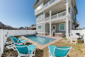 a house with a swimming pool and chairs at Dune it Wright at Carolina Shores in Nags Head