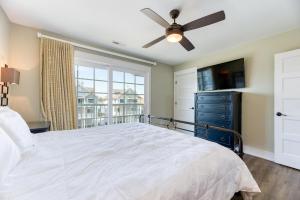 a bedroom with a large bed and a ceiling fan at Dune it Wright at Carolina Shores in Nags Head
