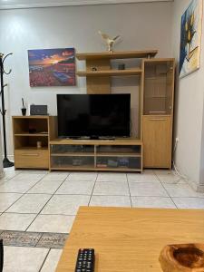 een woonkamer met een flatscreen-tv op een entertainmentcentrum bij ANGEL , Luxury 2BD apartment next to the Beach in Athene