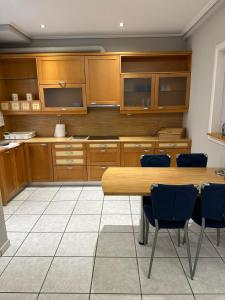 a kitchen with wooden cabinets and a table and chairs at ANGEL , Luxury 2BD apartment next to the Beach in Athens