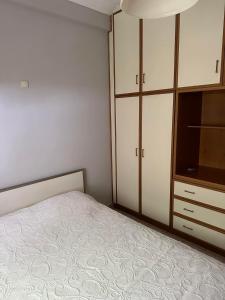 a bedroom with a bed and a dresser at ANGEL , Luxury 2BD apartment next to the Beach in Athens