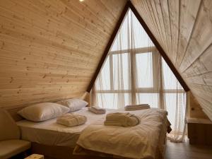 a bed in a room with a large window at Time House in Kokotauri