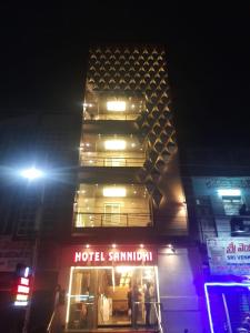 un edificio con un cartel de hotel delante de él por la noche en Hotel Sannidhi, en Vijayawāda