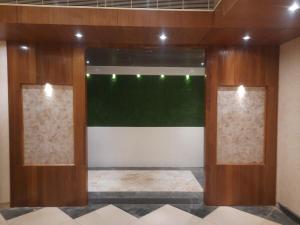 a room with two wooden doors and a green wall at Hotel Sannidhi in Vijayawāda