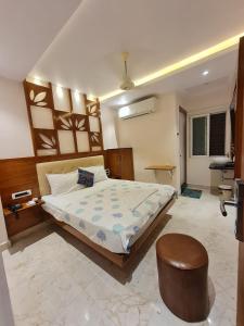 a bedroom with a large bed and a stool at Hotel Sannidhi in Vijayawāda
