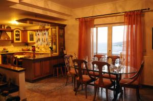 cocina con mesa con sillas y ventana en luxury villa samos, en Vathý