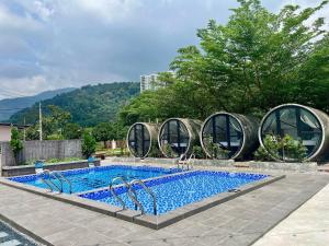 a swimming pool with a house with aqualivist architecture at Reserve The Cozytainer in Taiping