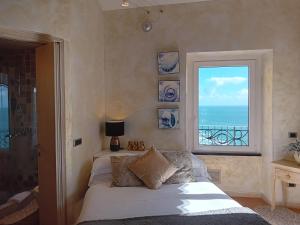a bedroom with a bed and a window with the ocean at Alla Porta Rossa in Manarola