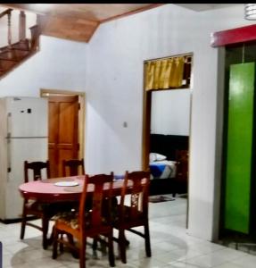uma cozinha com uma mesa e cadeiras e um frigorífico em Sewa Rumah 4 Kamar Tidur em Bandung