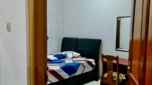 um quarto com uma cadeira azul com um cobertor em Sewa Rumah 4 Kamar Tidur em Bandung