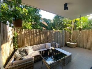 a patio with a couch and a coffee table at Beautiful 1 bedroom unit 1 block from Coogee beach in Sydney