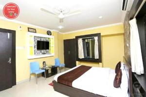 1 dormitorio con 1 cama, escritorio y TV en Hotel Sai Sandpiper Puri Near Sea Beach en Puri