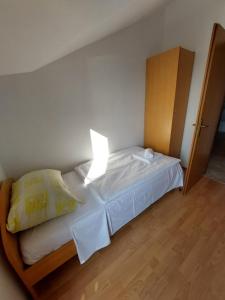 a bedroom with a bed with a lamp on it at Apartmani Romana in Punat