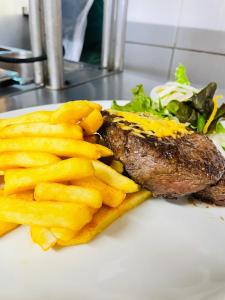 a plate of food with a steak and french fries at Aquarian Tide Hotel in Gaborone
