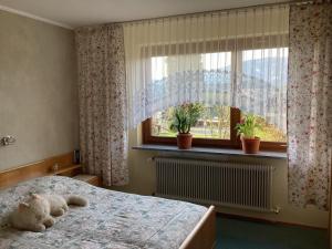 a bedroom with a teddy bear laying on a bed with a window at Pension Krüger in Seeboden